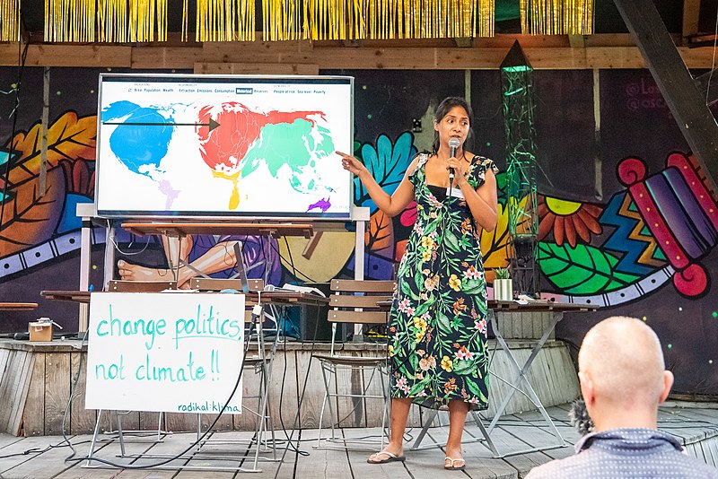 A woman uses a map as a visual aid during her speech.