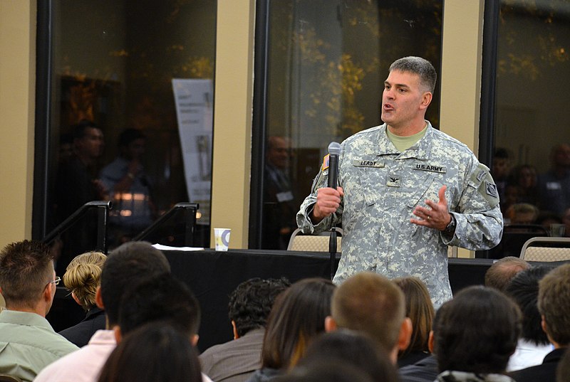 Soldier speaking to an audience of students.