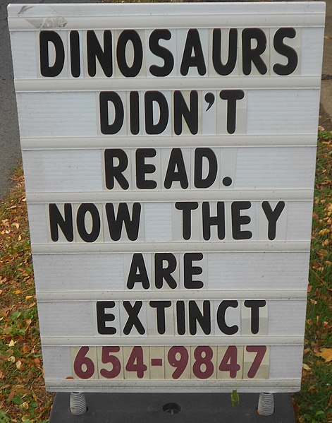 Sign that reads "Dinosaurs didn't read. Now they are extinct."