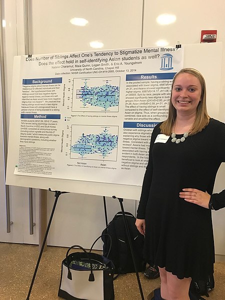 Woman standing next to her poster-board presentation.