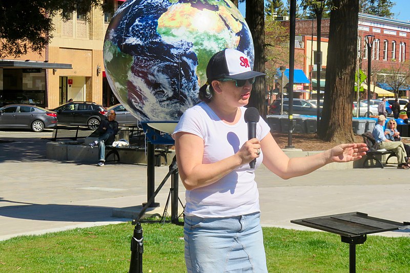 Woman addresses a group of people at a protest.