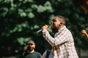 Young black speaking at a rally during the pandemic