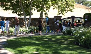 A small crowd gathers to leave flowers to outside Michael Jackson's mansion.